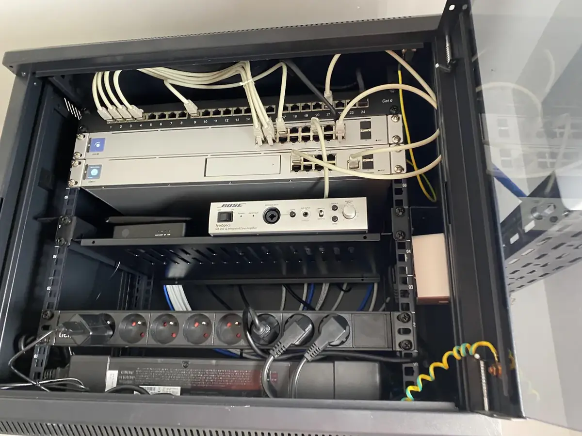 Baie technique combinant switching, contrôle et intégration audio Bose.