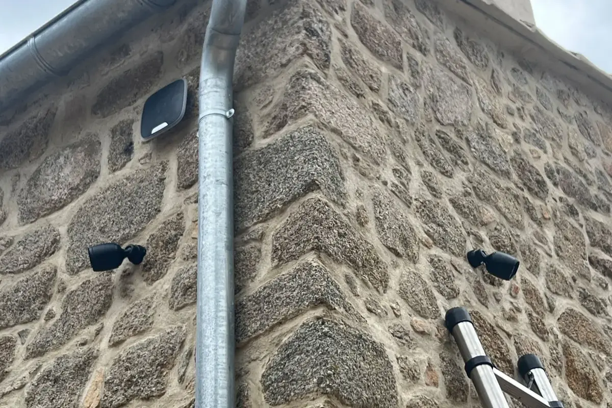 Caméras extérieures installées sur une façade en pierre pour une couverture multi-angle.